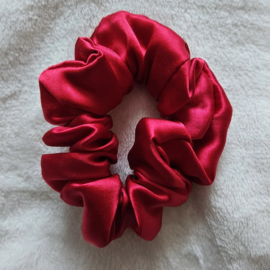 chouchou de couleur rouge bordeaux posé sur un fond blanc
