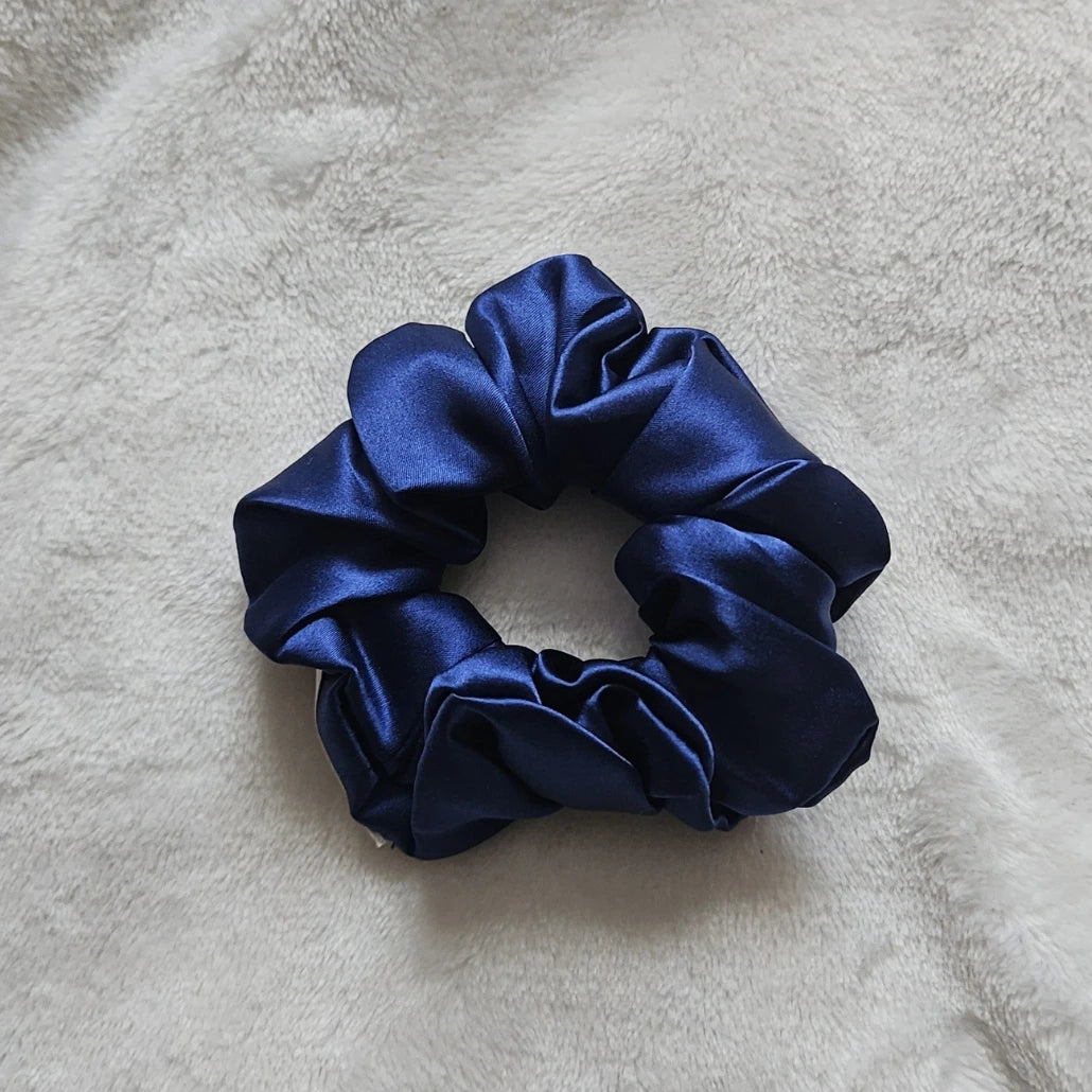 chouchou de couleur bleu marine posé sur un fond blanc