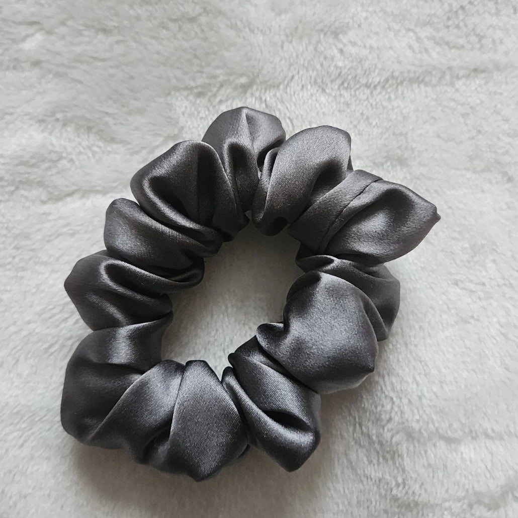 chouchou de couleur gris posé sur un fond blanc