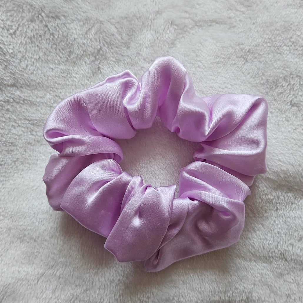 chouchou de couleur lilas posé sur un fond blanc