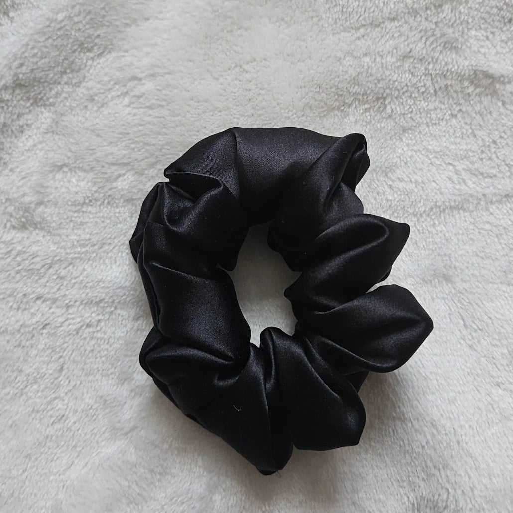 chouchou de couleur noir posé sur un fond blanc