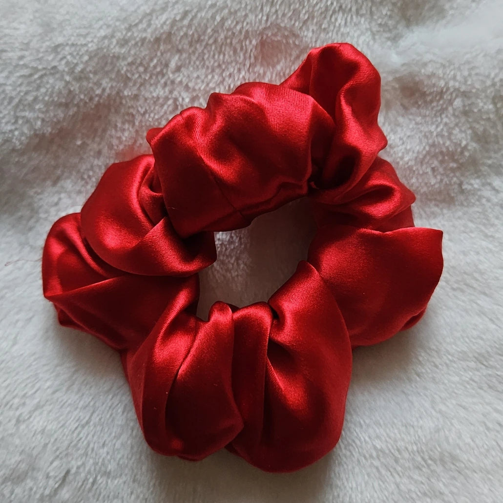 chouchou de couleur rouge posé sur un fond blanc