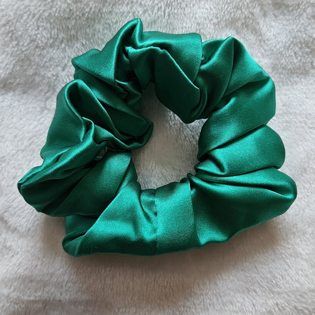 chouchou de couleur vert émeraude posé sur un fond blanc