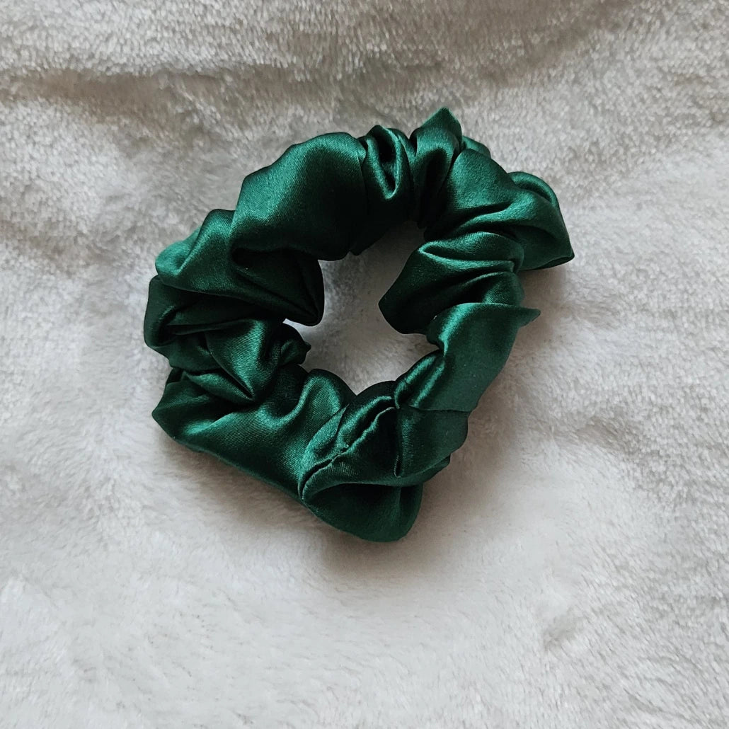 chouchou de couleur vert foncé posé sur un fond blanc